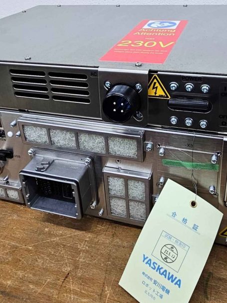 Ein elektronisches Gerät mit mehreren Anschlüssen und einem gelben Warnaufkleber.
