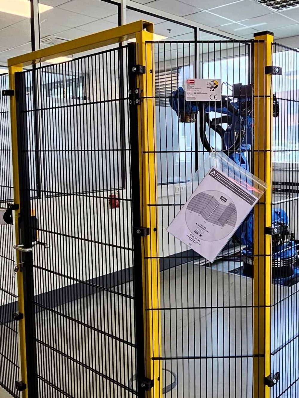 Ein abgesperrter Bereich mit einem Roboter und Sicherheitshinweisen.