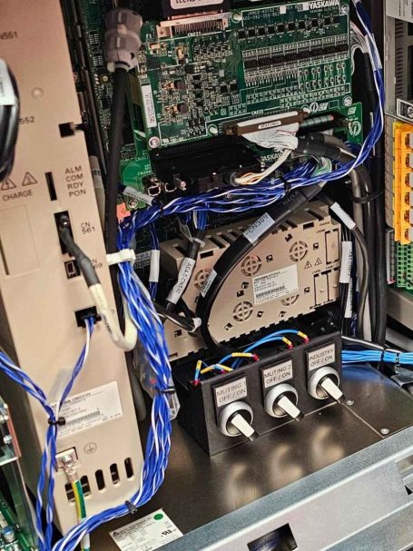 Innere Komponenten einer Robotersteuerung mit Schaltkreisen und Kabeln sichtbar.